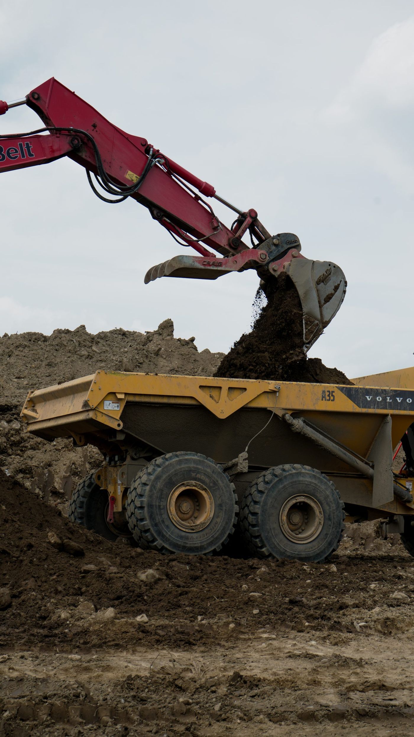 An excavator loading spoil into a haul truck.